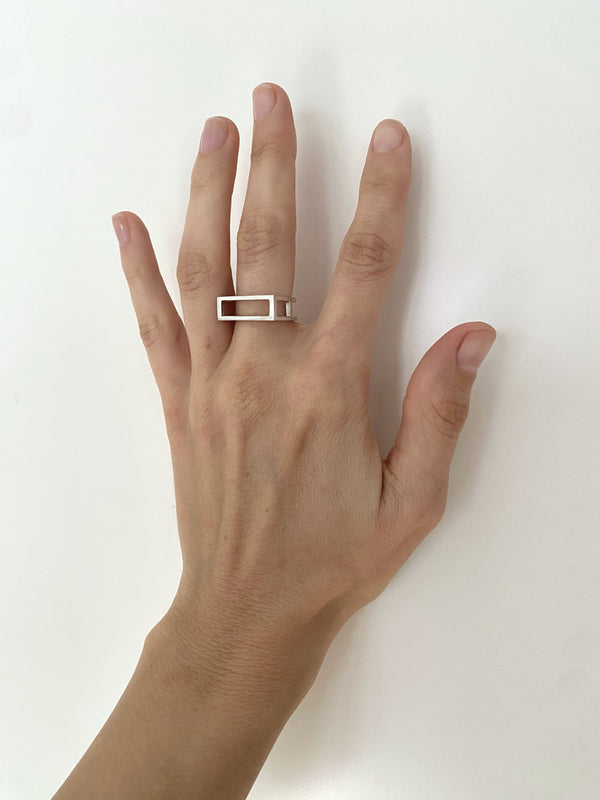 Hand wearing a silver ring on a white background