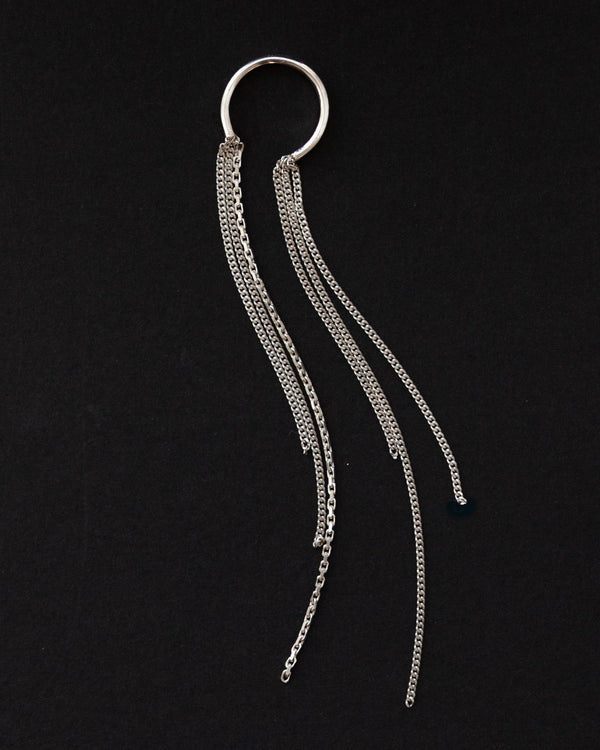 Silver ring with long dangling threads on a black background