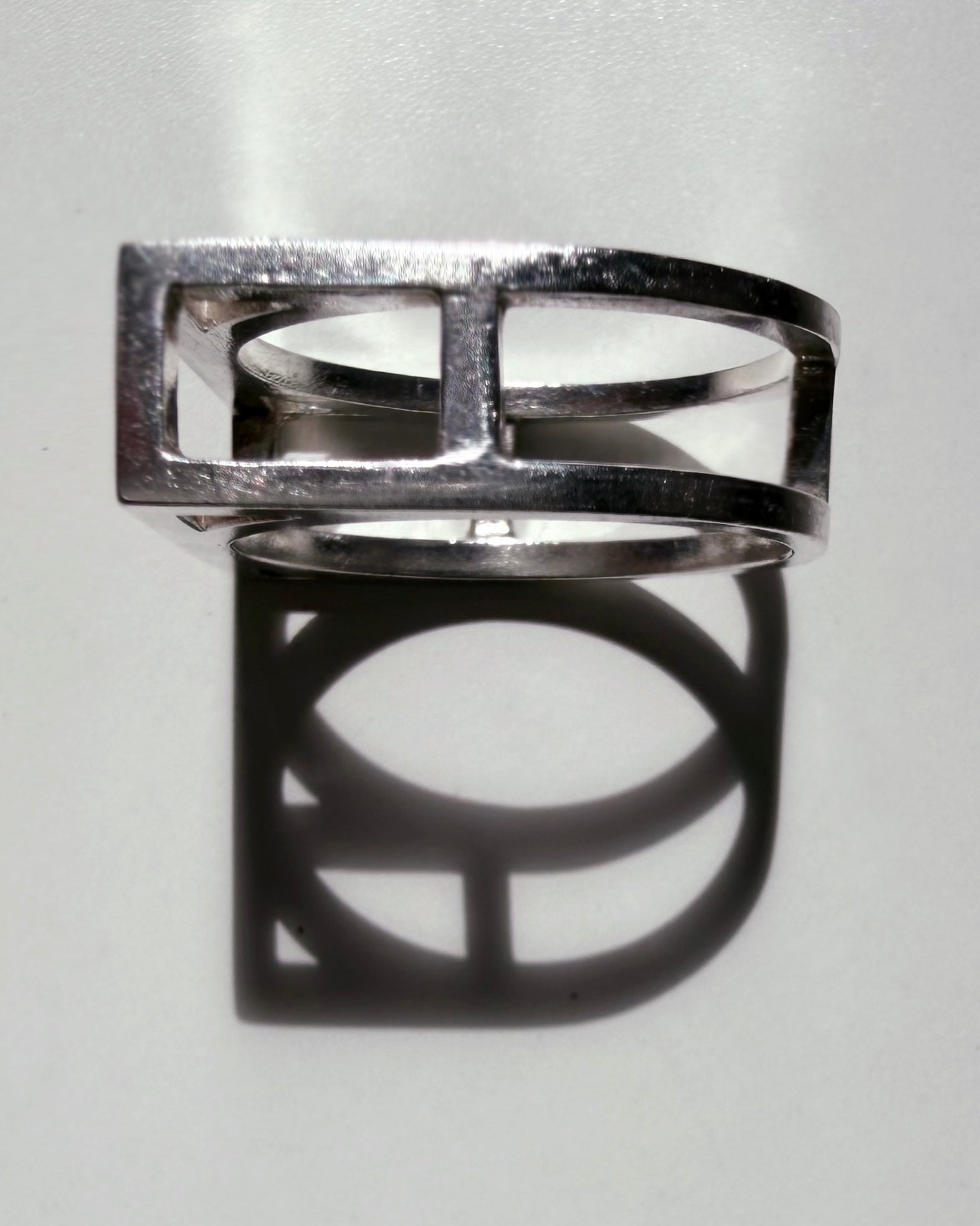 Silver ring with geometric design on a light gray background