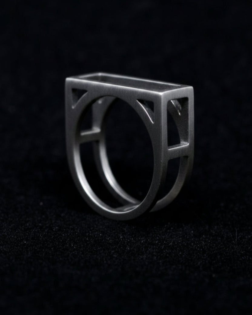 Silver ring with geometric design on a black background