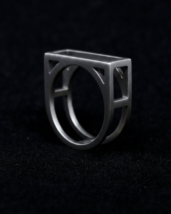 Silver ring with geometric design on a black background