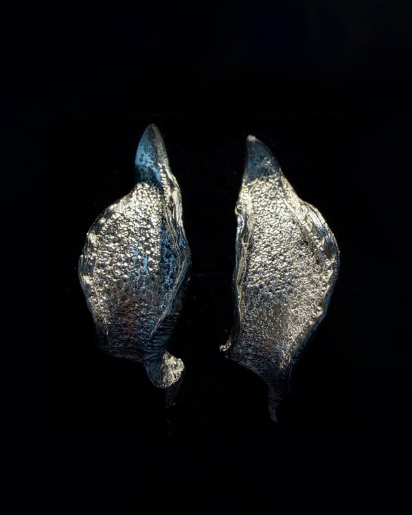 Pair of silver wave earrings on a black background